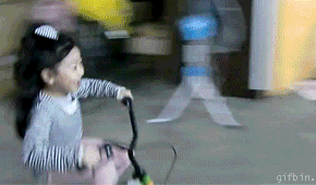 補助付き自転車で縦列駐車する女児