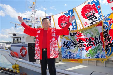 イベント会場となった増毛港中央埠頭で、大漁旗をバックに新曲のヒットを誓った細川たかし