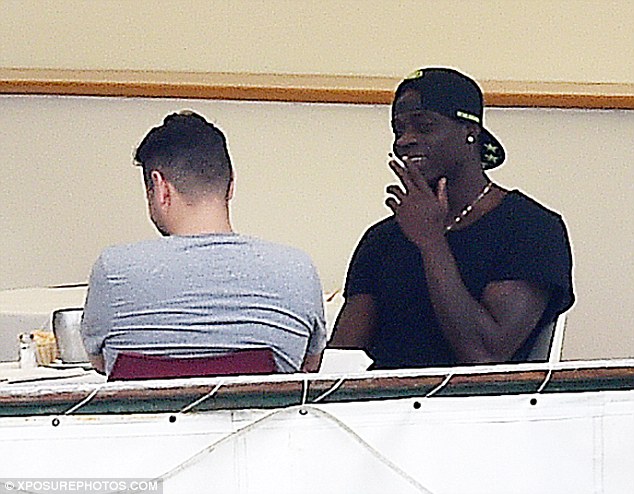 Balotelli seemed to be enjoying himself as he puffed away on a cigarette while with friends